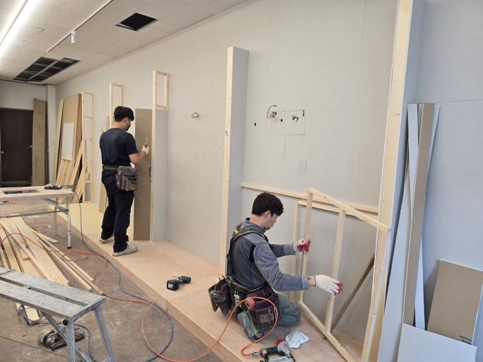 两名施工人员在现场搭建木基层墙体